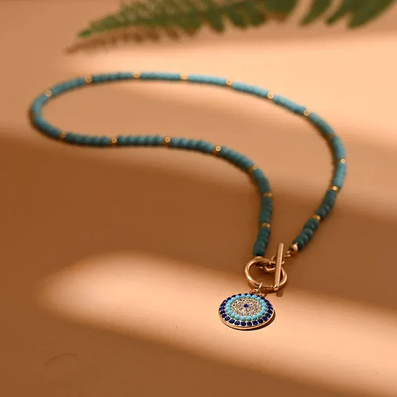 Flat lay of Colorful Stone Evil Eye Choker Necklace with accessories